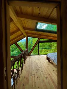 贾马里海姆森Riona dağ evleri的小屋内的卧室,铺有木地板,配有一张床