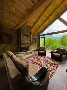 贾马里海姆森Riona dağ evleri的客厅配有沙发、椅子和壁炉