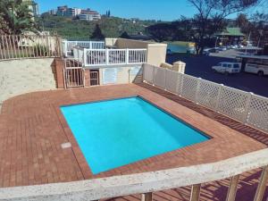 阿曼济姆托蒂Beachfront Apartments @ Amanzimtoti的一个带砖砌庭院和甲板的大型游泳池