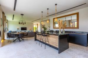 马拉喀什Villa Nounja Golf Amelkis Marrakech的厨房以及带桌椅的起居室。