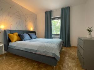 斯丹尼Garden Villa的一间卧室配有一张带蓝色床单的床和一扇窗户。