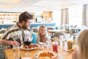 纽基访问不列颠3星银奖滨海酒店的坐在餐桌旁吃食物的男人和女孩
