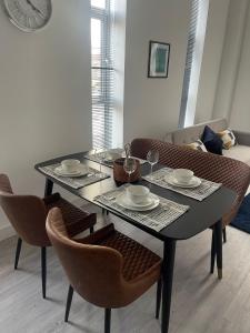 伍尔弗汉普顿Kingdom apartments的餐桌,带两把椅子和一张桌子,上面有盘子