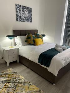 伍尔弗汉普顿Kingdom apartments的一间卧室配有一张带黄色枕头的大床