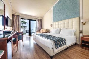 加尔多内-里维耶拉卡普里别墅酒店的配有一张床和一张书桌的酒店客房