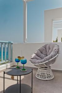 Kyra PanagiaEnilion Luxury Suites的椅子和两张带蓝色眼镜的桌子
