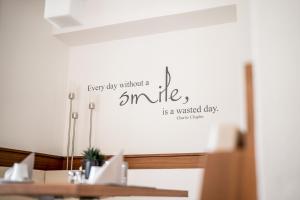 塞尔瓦迪加尔代纳山谷Arya Alpine Lodge的墙上有字牌,表示快乐的一天没有微笑,这真是浪费了一天