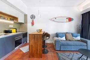 埃斯托利尔Estoril Art and Surf的一间带蓝色沙发的客厅和一间厨房