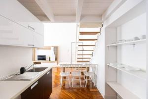 瓦雷泽Loft2 via morosini centro Varese - Ixihome的厨房设有楼梯和桌椅