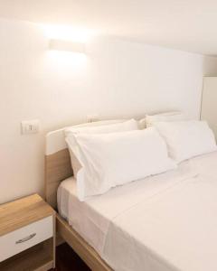 瓦雷泽Loft2 via morosini centro Varese - Ixihome的白色的床、白色枕头和床头柜