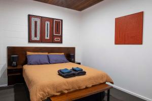 艾利斯斯普林斯4 Bedrooms, 2 Bathrooms in Alice Springs的一间卧室配有一张床,上面有两条毛巾