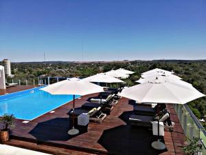 伊瓜苏港O2 Hotel Iguazu的游泳池旁的一排遮阳伞和椅子