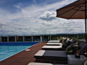 伊瓜苏港O2 Hotel Iguazu的游泳池旁的甲板配有躺椅和遮阳伞
