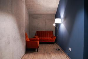 第比利斯EPIGRAPH Design Hotel的客厅配有红色的沙发和灯具