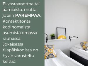 赫尔辛基Hiisi Homes Helsinki Sörnäinen的一间卧室设有两张床和一个阅读la victoria tallennaenna的标志。