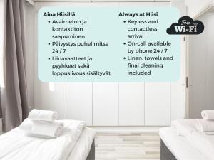 赫尔辛基Hiisi Homes Helsinki Sörnäinen的白色的房间,有两张床,墙上有字
