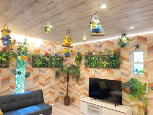 大阪Hotel Jungle fun fun的客厅配有电视和装饰墙