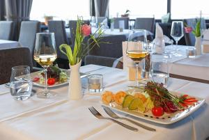 巴登-巴登Hotel Restaurant Haus Rebland的一张桌子,上面放着两盘食物和酒杯