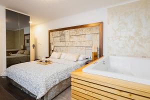 普利特维采湖格兰德湖酒店的一间卧室设有一张大床和一个浴缸