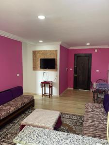 Ez Zahracosy Furnished appartment的客厅设有紫色墙壁和沙发