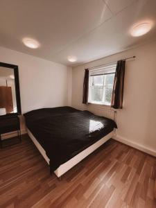 塞济斯菲厄泽Cozy apartment in Seydisfjordur的一间卧室设有一张黑色的床和一个窗户。