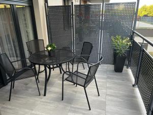 卡利什Apartament Korczak Park的阳台上配有一张黑色的桌子和椅子