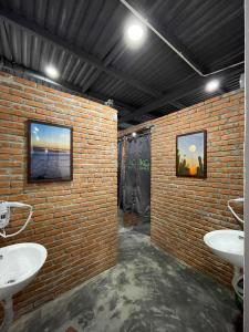 岘港IKIGAI Dorm Hostel - Danang Beach的砖砌浴室,设有两个水槽和砖墙