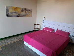 因佩里亚Casa Gazzano的一间卧室配有一张带粉红色床单的大床