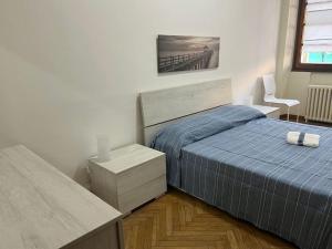 热那亚Lido Blu的一间卧室配有一张床、一张桌子和一把椅子