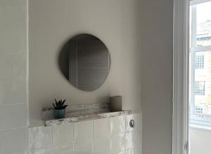 哈罗盖特Strawberry Dale Apartment的白色墙壁上带镜子的浴室