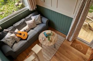 拉伊Extraordinary Huts Ltd的带沙发和吉他的客厅