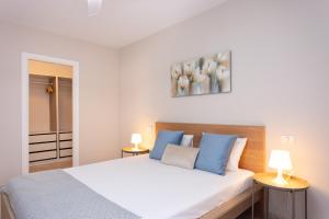 坎德拉里亚Home2Book Attic Terrace Apt Charming Ocean View的卧室配有白色的床和两盏灯。