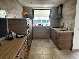 马斯帕洛马斯Chalet Privato con Jacuzzi New的厨房配有木制橱柜、水槽和窗户。