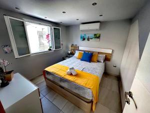 马斯帕洛马斯Chalet Privato con Jacuzzi New的一间卧室配有一张带黄色毯子和窗户的床