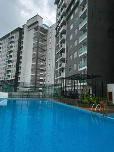雪邦Ilsham Guest House @ Seroja Hills BBST Sepang的一座大型蓝色游泳池,位于部分建筑前