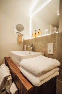 贝塞尔Hotel MeerZeiten inklusive externer Schwimmbad- & Saunanutzung的浴室设有水槽和台面上的白色毛巾