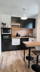 萨利耶德贝阿尔恩Les Treilles de Salies - Studio au calme的厨房配有黑色橱柜和木桌