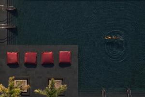 阿基欧斯尼古拉斯米诺斯宫套房酒店 - 仅限成人入住的水体旁的一座建筑,有红色的垫子