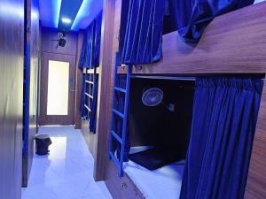 孟买Kohinoor Dormitory的客房设有两张双层床和蓝色窗帘
