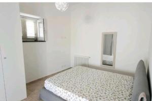 利帕里Casa Eoliana的白色卧室配有床和镜子