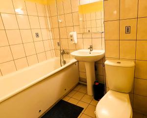 Ligny-en-BarroisHôtel Le Valéran的浴室配有卫生间、盥洗盆和浴缸。