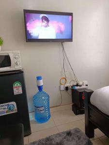 内罗毕Blue Falls Queen Studio的客房内提供1瓶大瓶水,配有电视