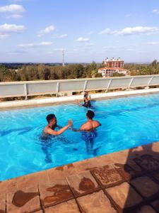 内罗毕Blue Falls Queen Studio的两个人在游泳池玩耍