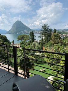 卢加诺卡斯塔尼奥拉大酒店的阳台享有湖泊和山脉的美景。