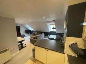 内尔斯沃思Modern loft retreat in the heart of Nailsworth的厨房以及带沙发和桌子的客厅。