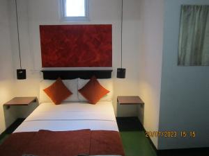 康提My city Beds的一间卧室配有一张带橙色枕头的大床