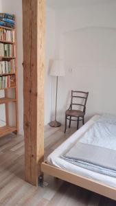 斯特拉科尼采Apartmán Malá Turná的一间卧室配有一张床、一把椅子和一个书架
