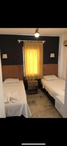 博德鲁姆Kılavuz otel的一间设有两张床和黄色窗帘的房间