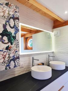 多勒Cabanes du Domaine des Fées的浴室设有2个水槽和花卉壁纸