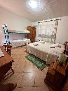 LoceriAgriturismo Su Barraccu的一间卧室设有两张单人床和一个窗户。